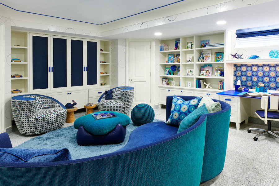 Mixed patterns and vibrant blue rug and furniture give this playroom designed by Jenny Kirschner a pl