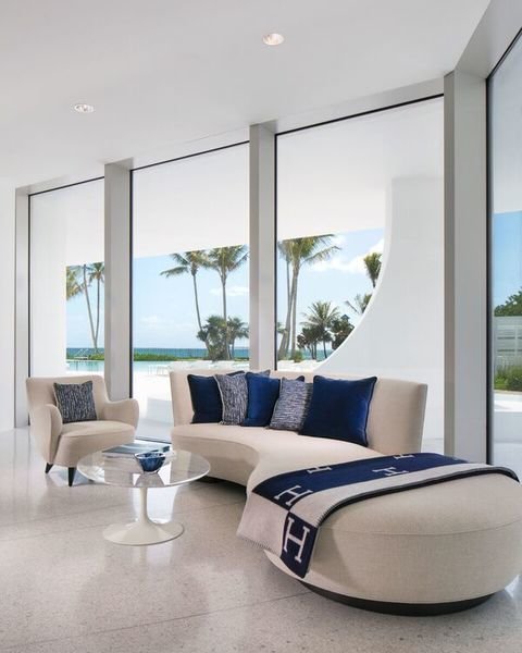 Punctuated by navy throw pillows and a blanket, this room designed by Pierre-Yves Rochon creates inte